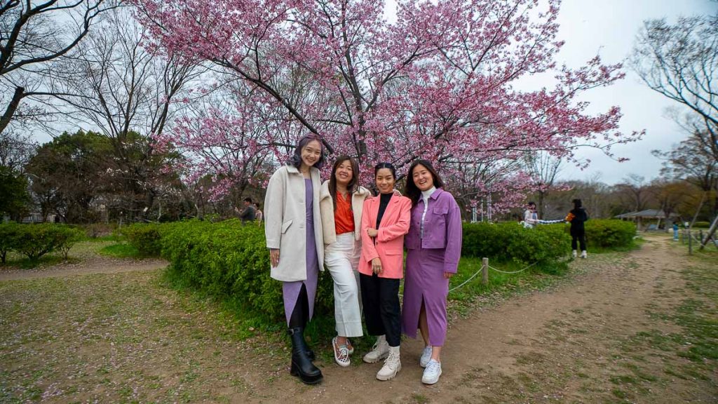 Group of girls posing with cherry blossoms in Japan – Travel outfits for Spring
