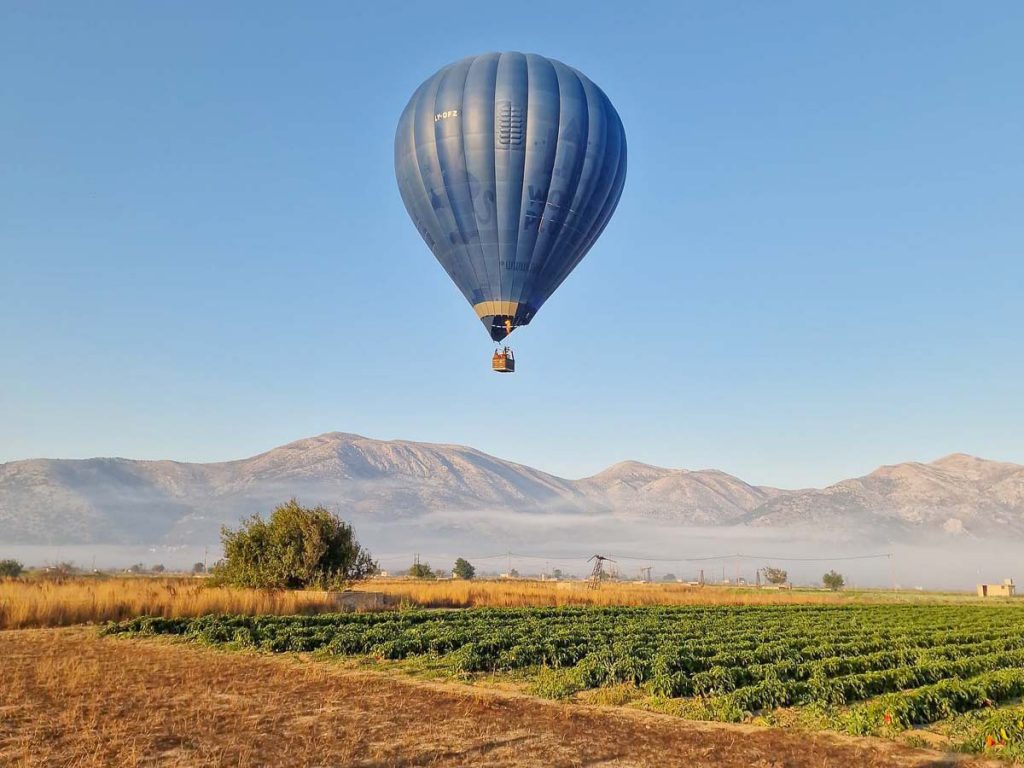 Scenic Landscape with Hot Air Balloon - Greece Bucket List