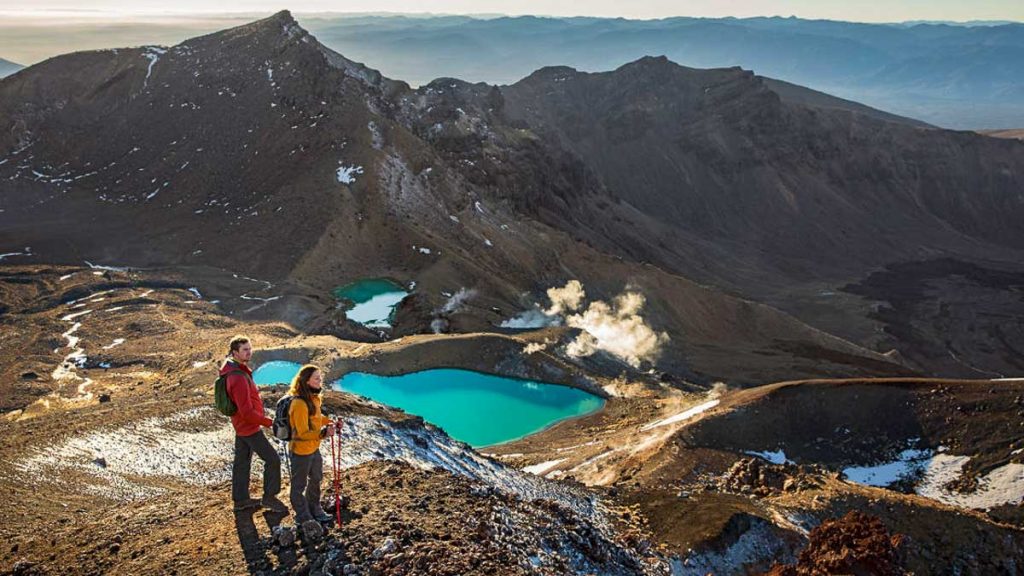 Couple overlooking the emerald pools of Tongariro Alpine Crossing