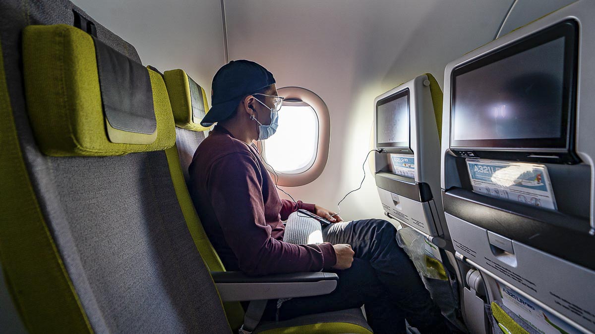 Homme voyageant en avion avec masque facial - Réouverture de la Chine