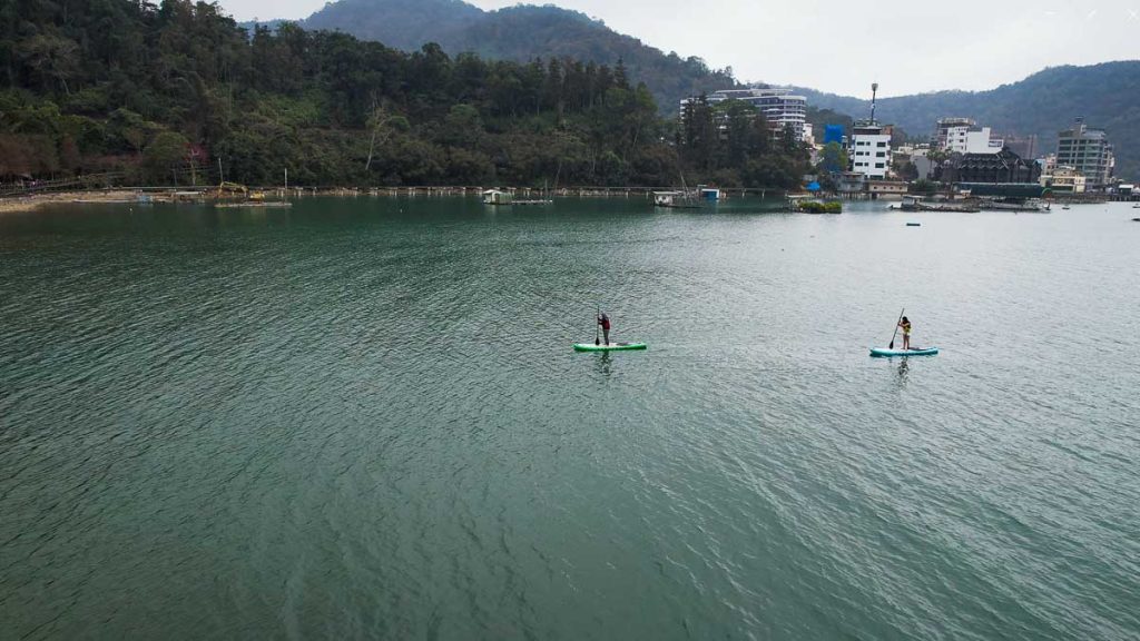 2 people stand-up paddle boarding in Sun Moon Lake - things to do in Taiwan