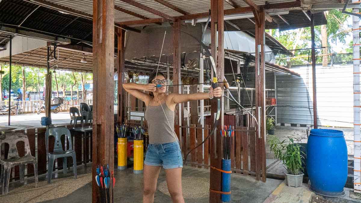Girl playing archery at Belalang Adventure - Things to do in Batam