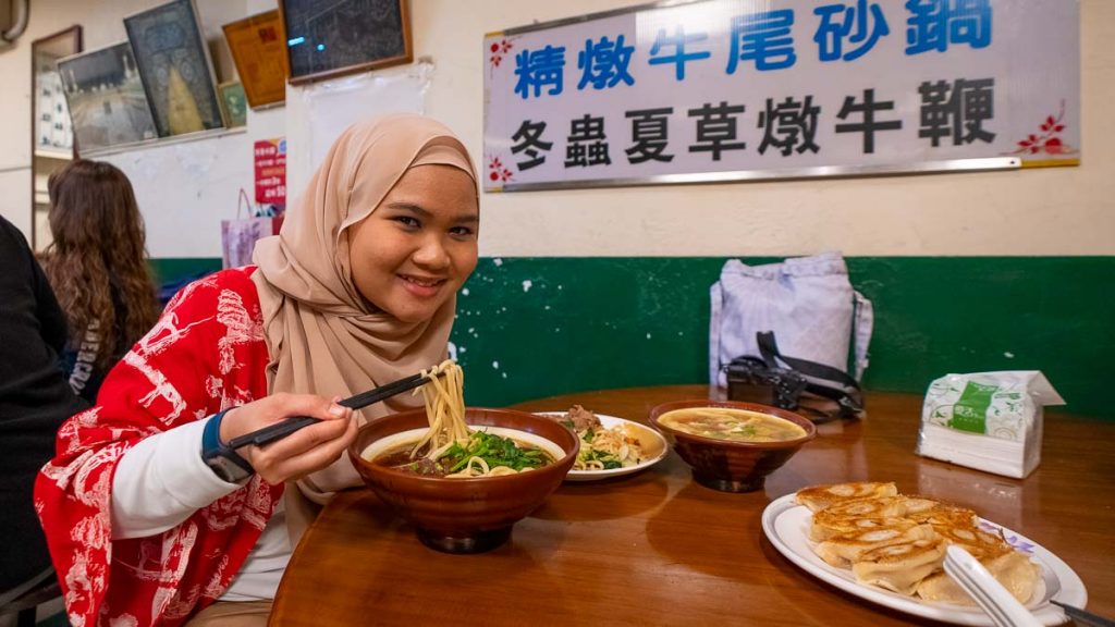 girl eating noodles at halal hall - things to do in taichung