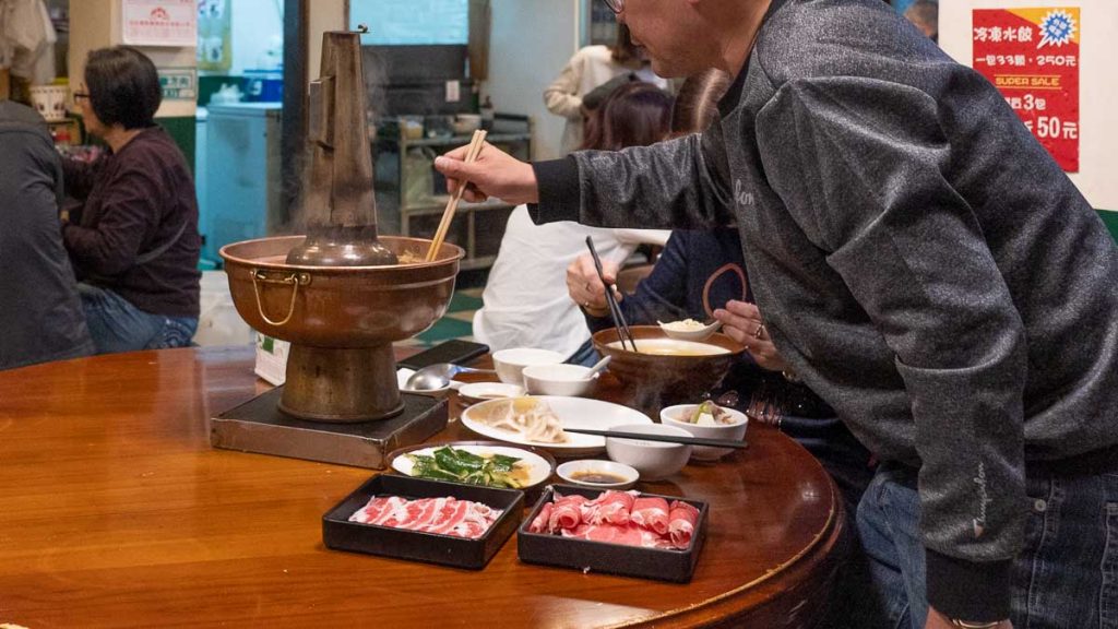 man stirring hot pot in halal hall restaurant - things to do in taichung