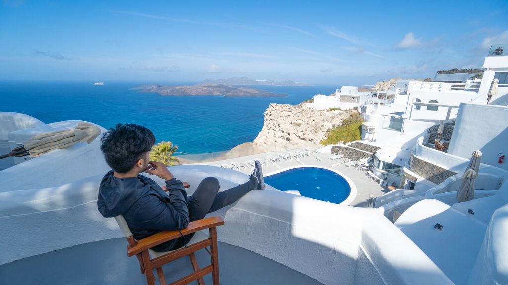 Man Looking at Volcanic View Hotel Balcony - Greece Itinerary