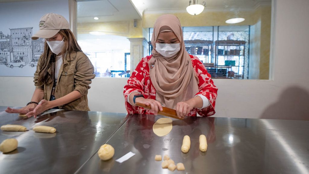 girls rolling out sun cake dough in taiwan sun cake museum workshop - things to do in taichung