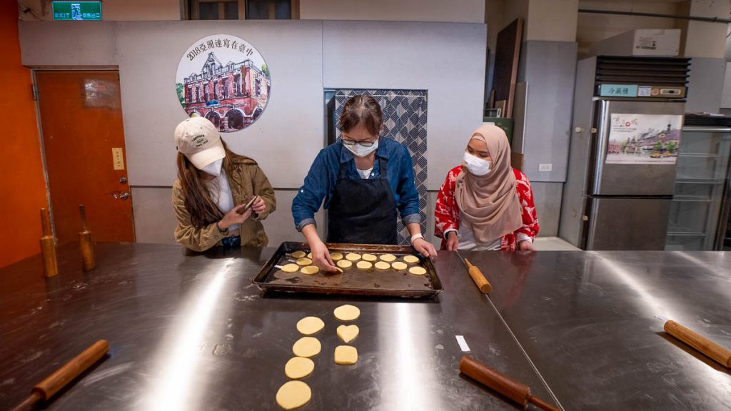 an instructor teaching 2 girls how to make sun cake - thin to do in taichung