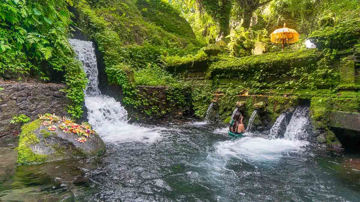 Woman taking part in holy water ceremony at Pura Meninging Water Temple - Wellness tour in Ubud