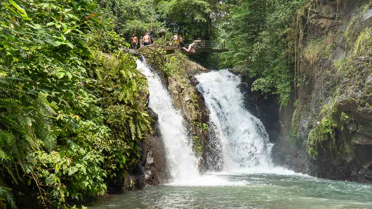 Woman jumping off Kembar Waterfall - Bali Itinerary