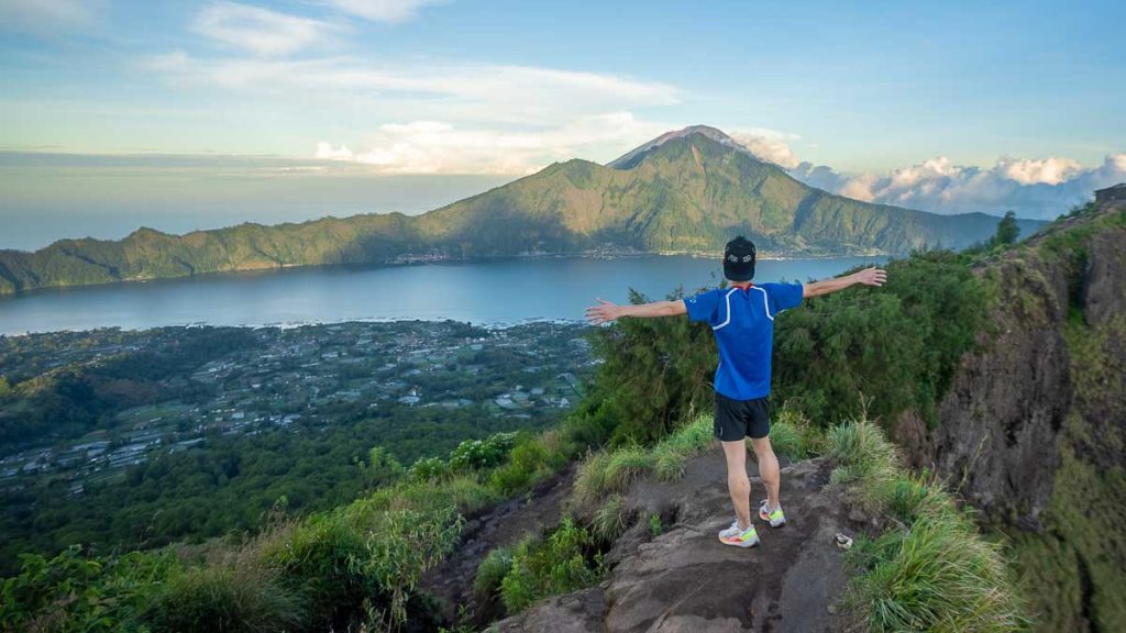 Man standing at the peak of Mt Batur - 2024 Public Holidays Singapore