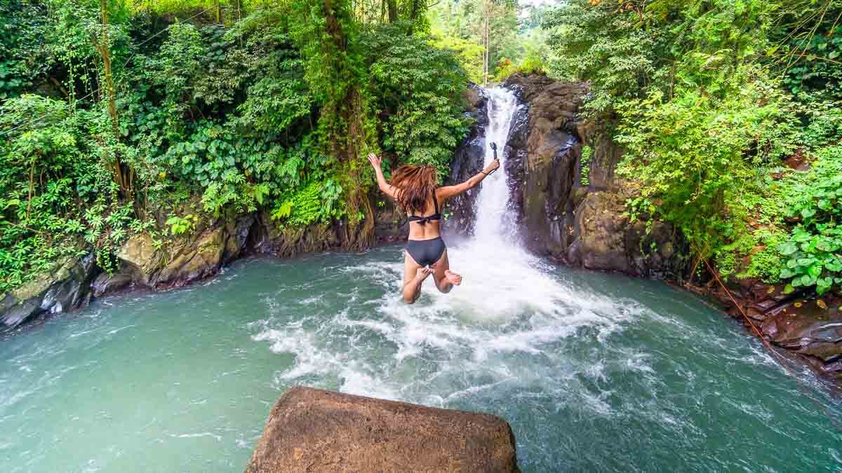 Woman jumping off Kroya Waterfall - Bali Itinerary