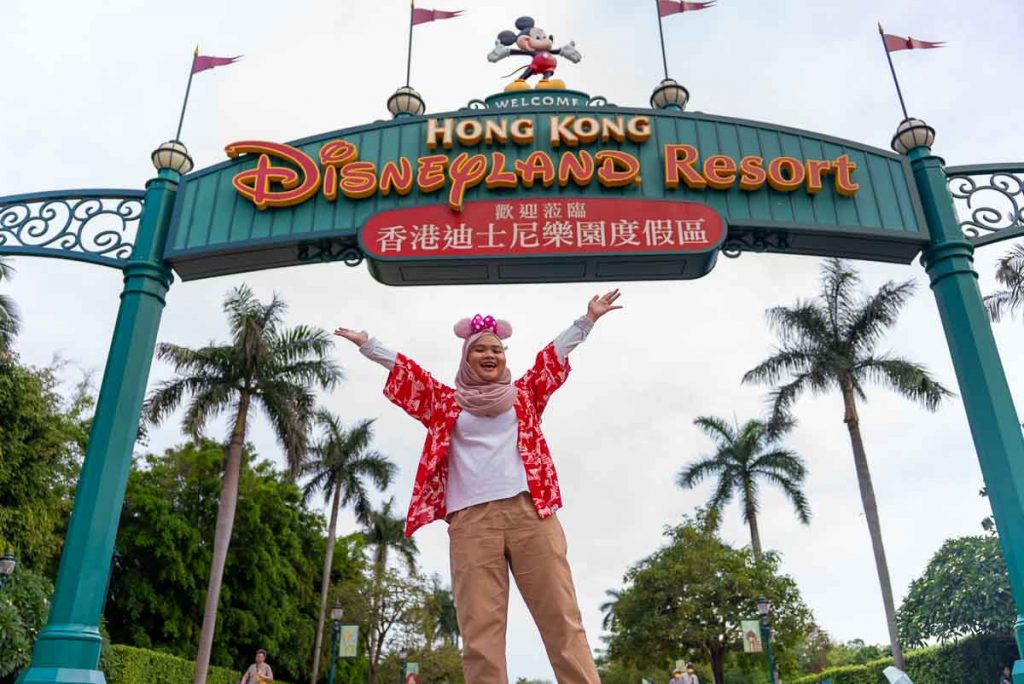 a girl in a hijab posing outside hong kong disneyland - Muslim-friendly attractions in Hong Kong
