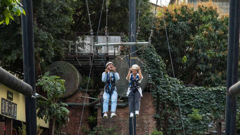 Two friends swinging down the Sky Swing in Ten Drum Village