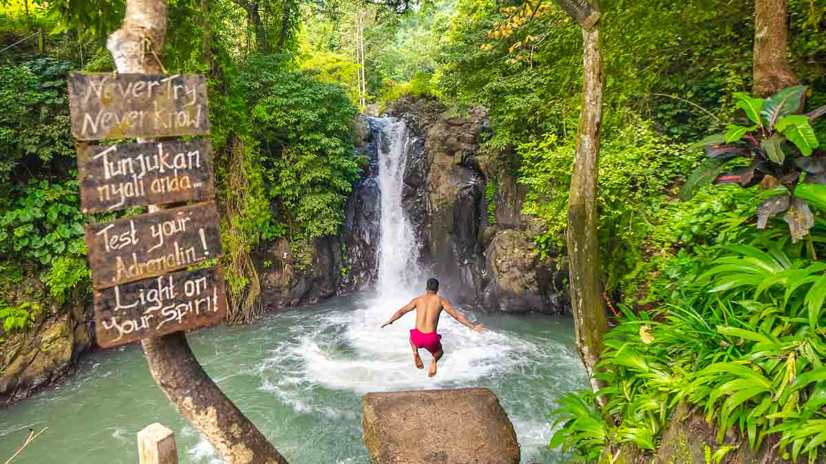 Man cliff jumping at Kroya Waterfall in North Bali
