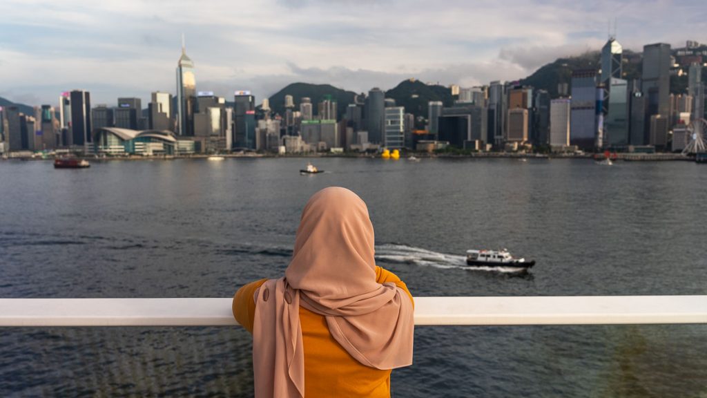 girl in a hijab looking out at victoria harbour - hong kong itinerary