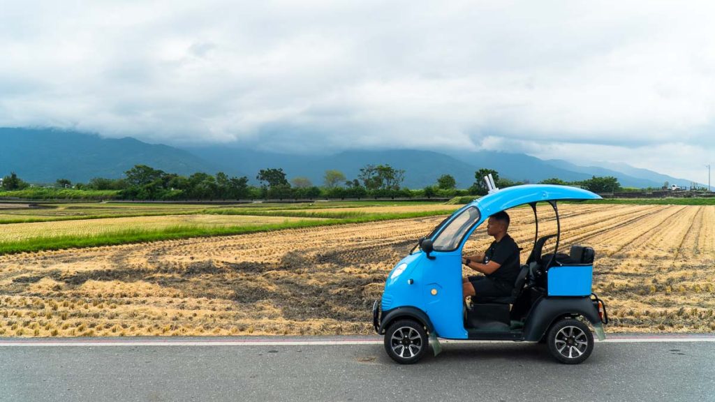Man driving a tuktuk in front of a rice field in Chishang - Things to do in Chishang