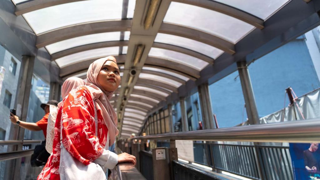 a girl in a hijab looking out at the central mid levels escalators - Exploring Hong Kong as a Muslim traveller