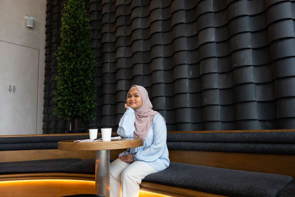 girl in hijab sitting in front of tile wall in cupping room hong kong palace museum - cafes in Hong kong