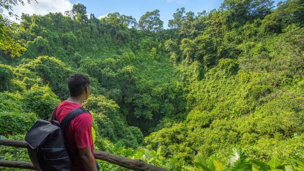 Man Looking at Volcanic Crater - Hainan Itinerary