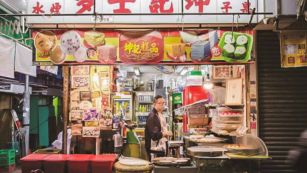 Owner (man) stands in his street food stall at night - Things To Do In Hong Kong, Sham Shui Po 