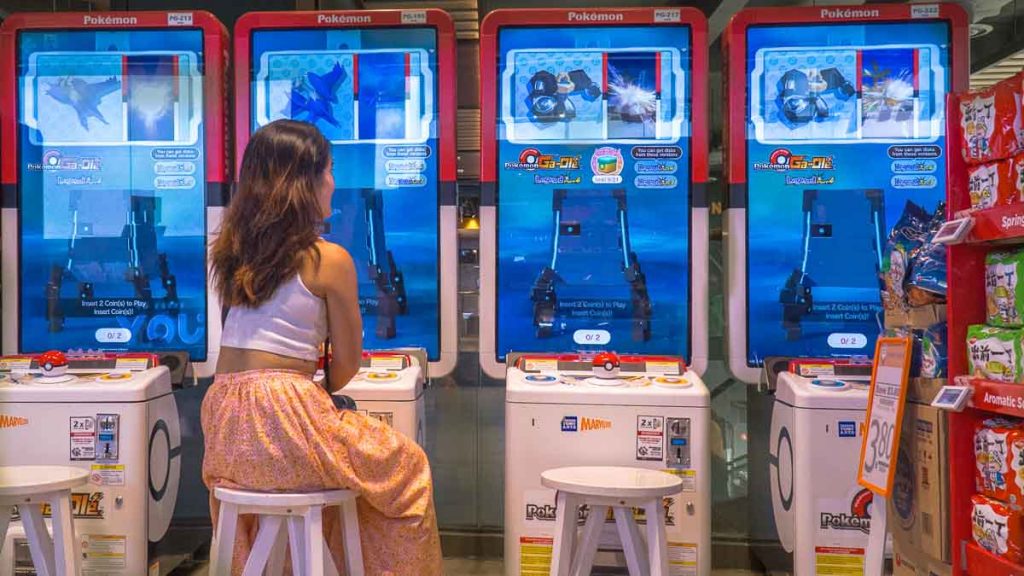Girl sits at row of Ang Mo Kio Fairprice Finest Pokemon arcade - Things To Do In Ang Mo Kio
