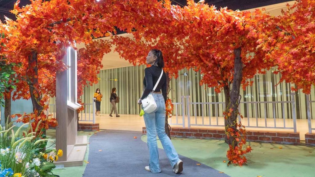 Girl Under Orange Foliage - Changi Airport Terminal 2