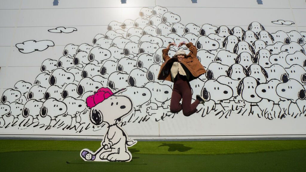 Girl jump in front of Photo Op Wall at Snoopy Museum - Non-Touristy Tokyo