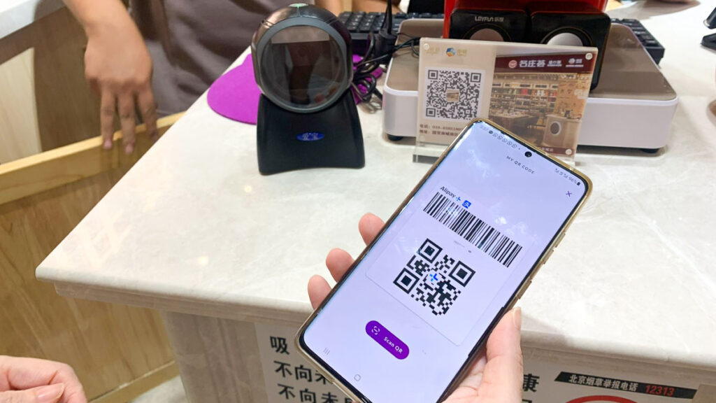 Hand Holding Phone with QR Code - QR Code Payments
