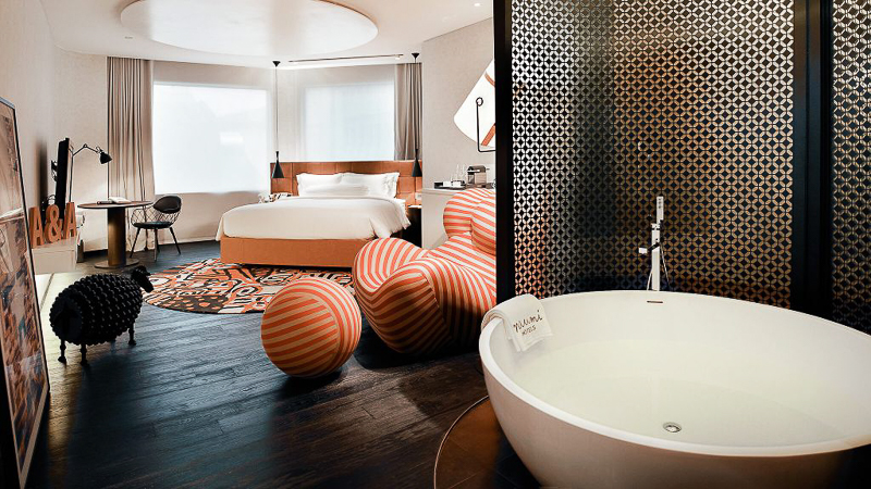 Interior Naumi Hotel, featuring a bathtub and “Donna”, a limited edition Italian armchair as a centrepiece of the room - alongside other whismical furnishings inspired by Andy Warhol. 