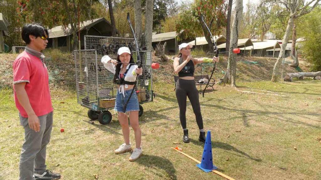 Two girls being taught archery in Saiyuen - Hong Kong Itinerary