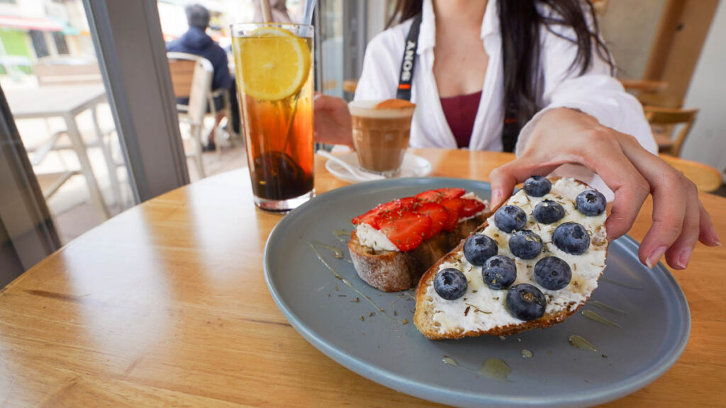 close up of a girl holding up the blueberry ricotta cheese toast