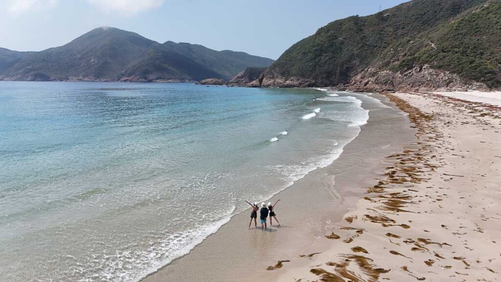 Drone shot of three friends on a beach in Hong Kong - Hong Kong Itinerary