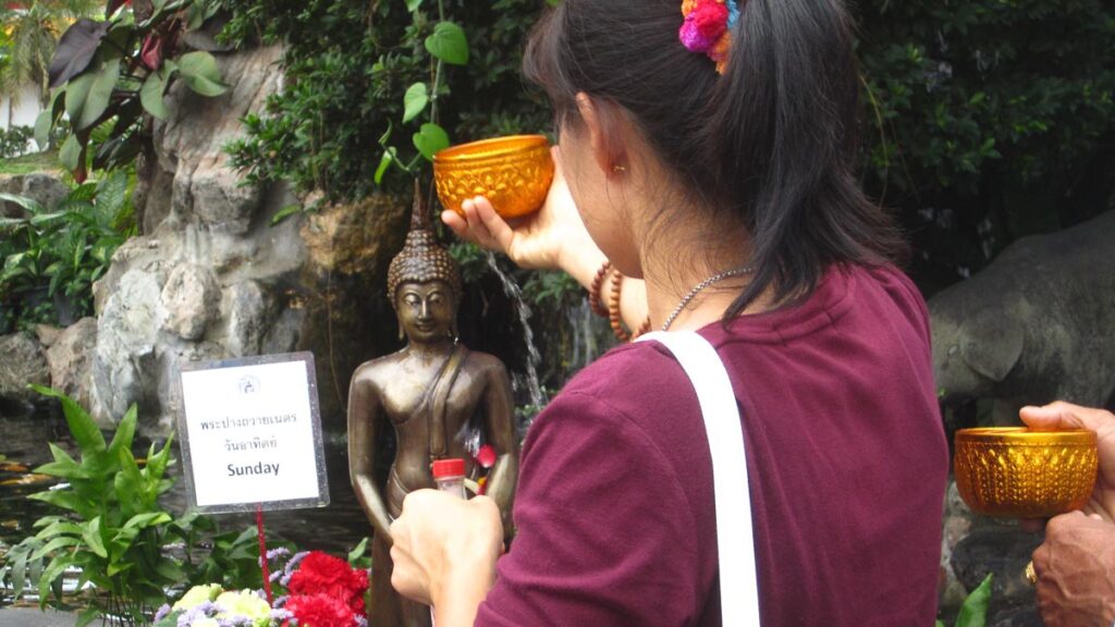 Girl Bathing Buddha Statue - Festivals in Thailand