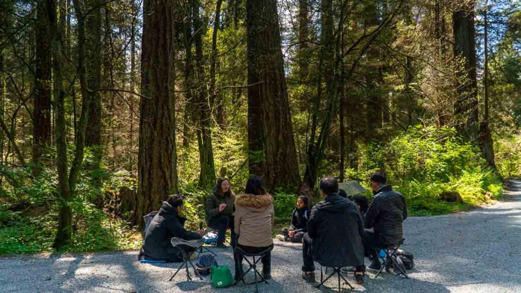 Group gathered in a circle for forest bathing therapy in Stanley Park - Things to do in Vancouver