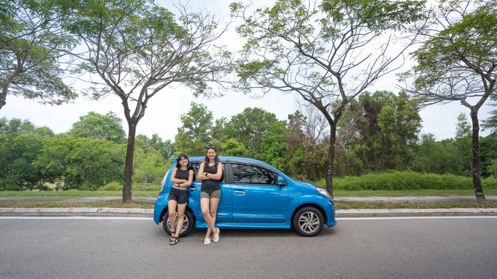 People posing against Perodua Myvi Car