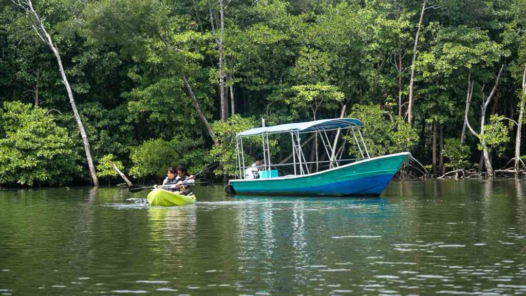 Kayak beside boat on River Lebam - Things to Do in Desaru