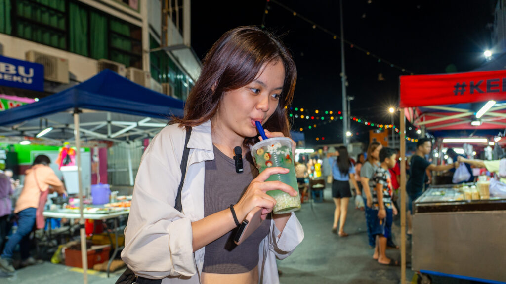 Woman trying the five flavours soup in Sibu night market - Sarawak guide
