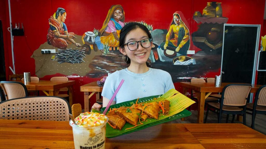 Girl posing with chicken masala thosat and biscoff milkshake at Madras - Skudai Food Guide
