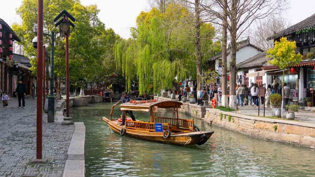 An old man rowing a boat down the canal in Zhujiajiao Water Town - Shanghai attractions