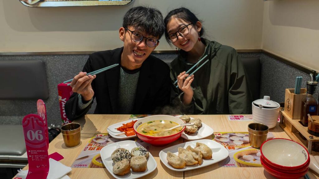 LY and Jensen smiling with their food at Yang's Dumplings - Things to eat in Shanghai