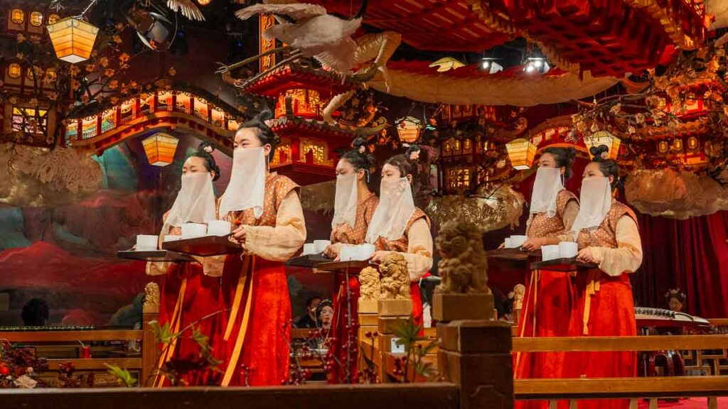 Xuyan staff walking down the stage holding trays of food for diners - Xuyan itinerary