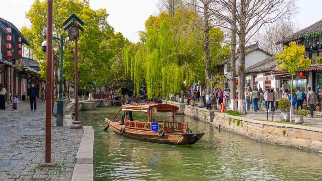 A man pushing his boat in the canal in Zhujiajiao Water Town - Things to do in Shanghai