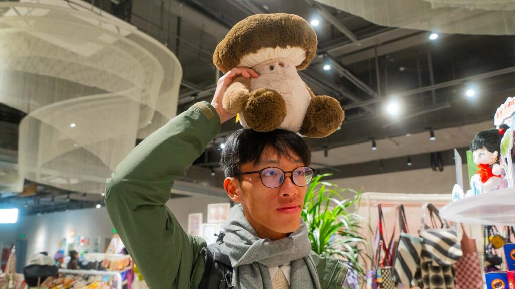 Jensen posing with a stuffed toy mushroom on top of his head at Foo Market - Zikawei Library