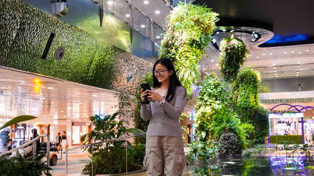 Girl at Changi Airport Using Phone - Nomad eSIM