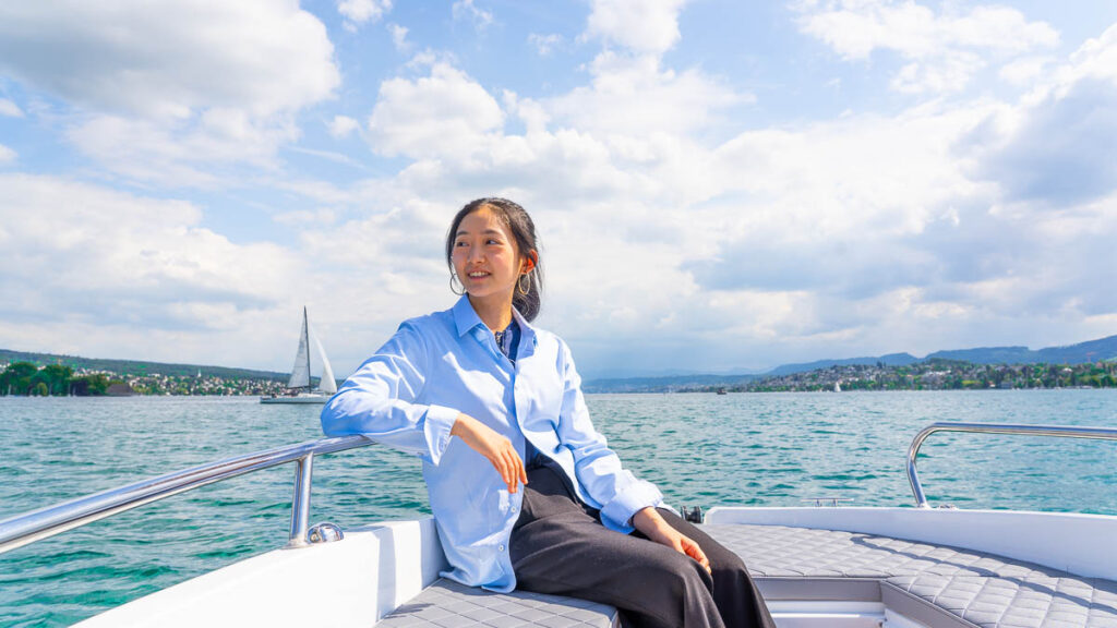 Taukee sitting on an e-boat on Lake Zurich - Things To Do In Zurich