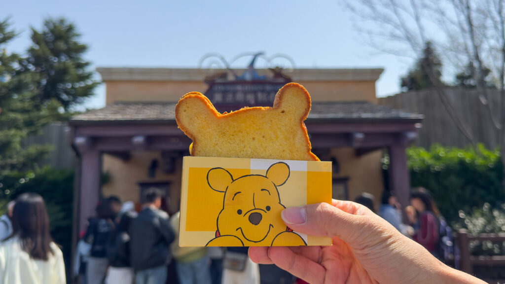 A hand holding a Winne-the-Pooh shaped sandwich up - Shanghai Disneyland