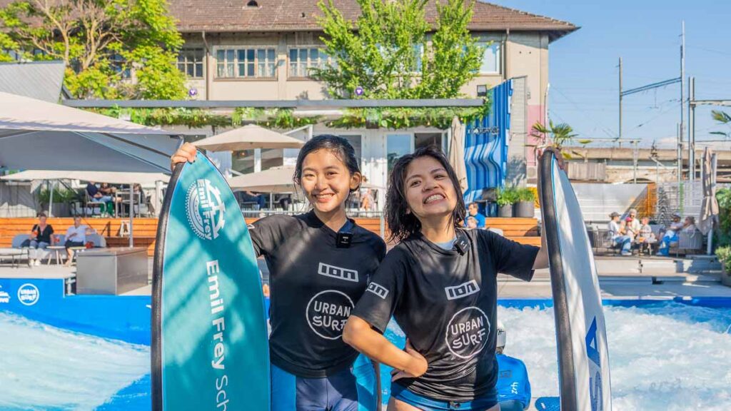 Tracey and Taukee posing with their surfboards at urban surf - Things to do in Zurich