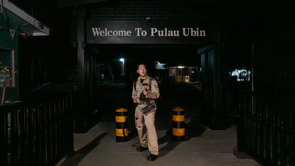 Boy_in_Ghostbuster_costume_standing_in_front_of_Pulau_Ubin_Signage