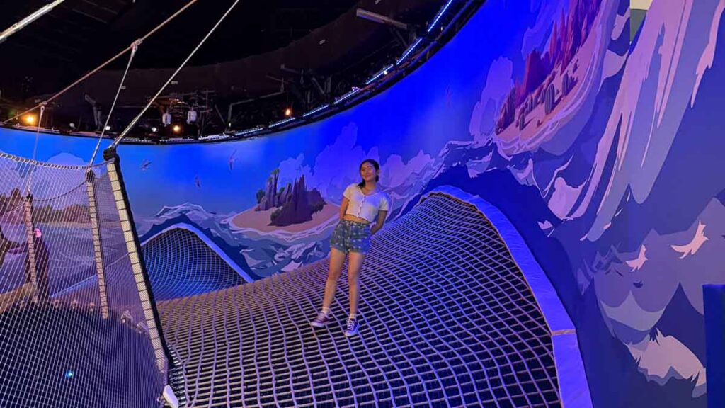 A girl standing at the bouncy nets at Pier Adventure