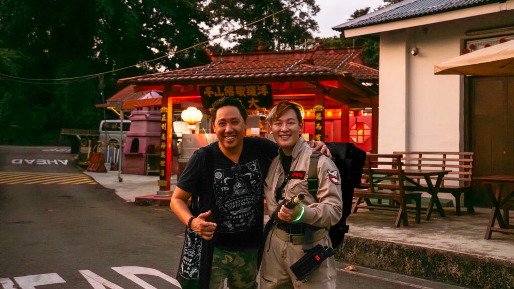 Two_people,_one_in_a_ghostbuster_costume_posing_in_front_of_a_Chinese
